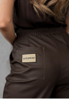 Woskowane spodnie She Is Strong czekoladowe